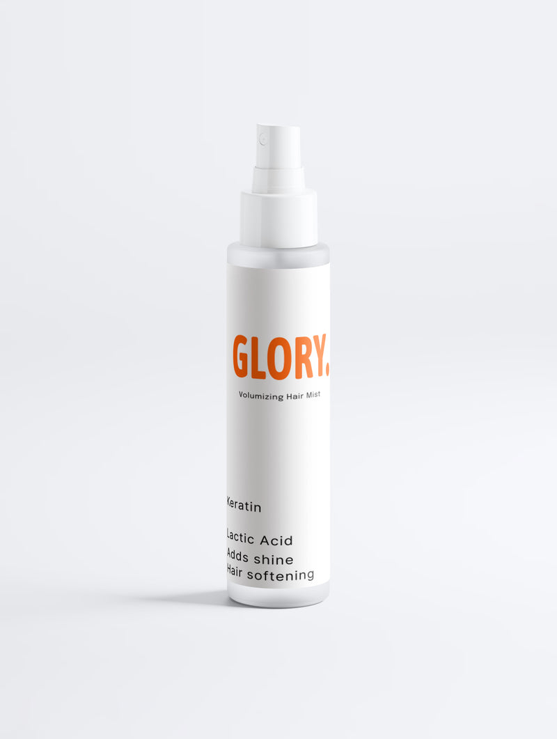 A white spray bottle of GLORY Volumizing Hair Mist with orange and black text, set against a clean white background.